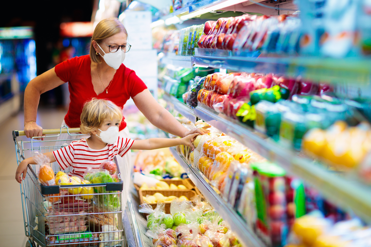 Donna e bambino con il carrello acquistano cibo