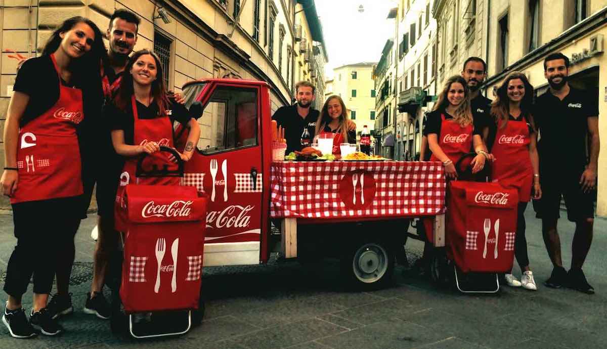 Hostess e Promoter durante uno Street Marketing per Coca-Cola. Esempio di Canale di Distribuzione indiretto tramite agenti o agenzie esterne.