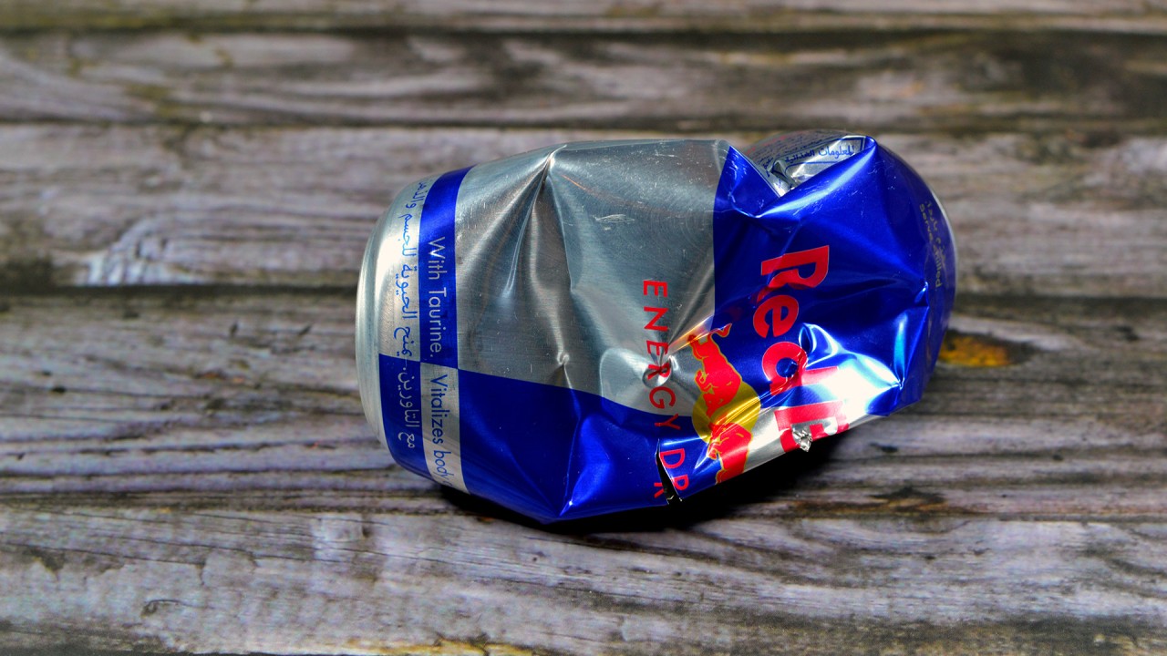 Redbull: lattina schiacciata su pavimento di legno