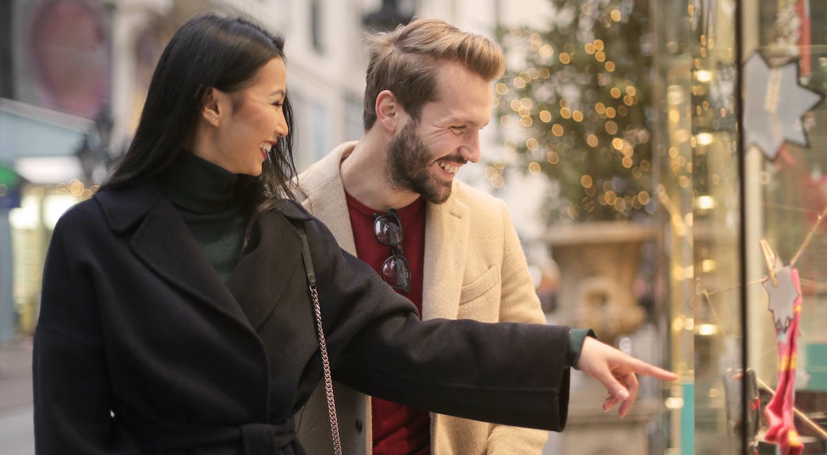 coppia che indica una vetrina nel periodo natalizio